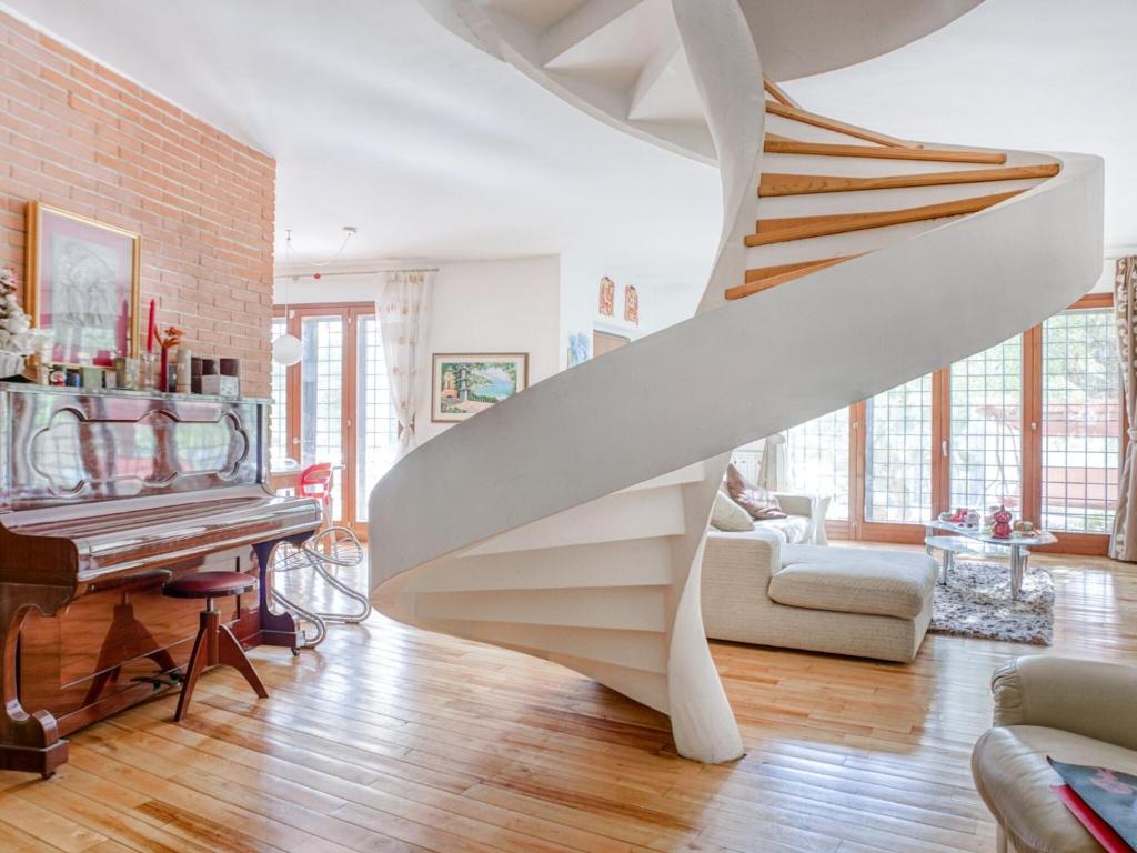 escalera blanca en la sala de estar con piano en Comfortable Villa in Roma with Garden and Barbecue, en Roma