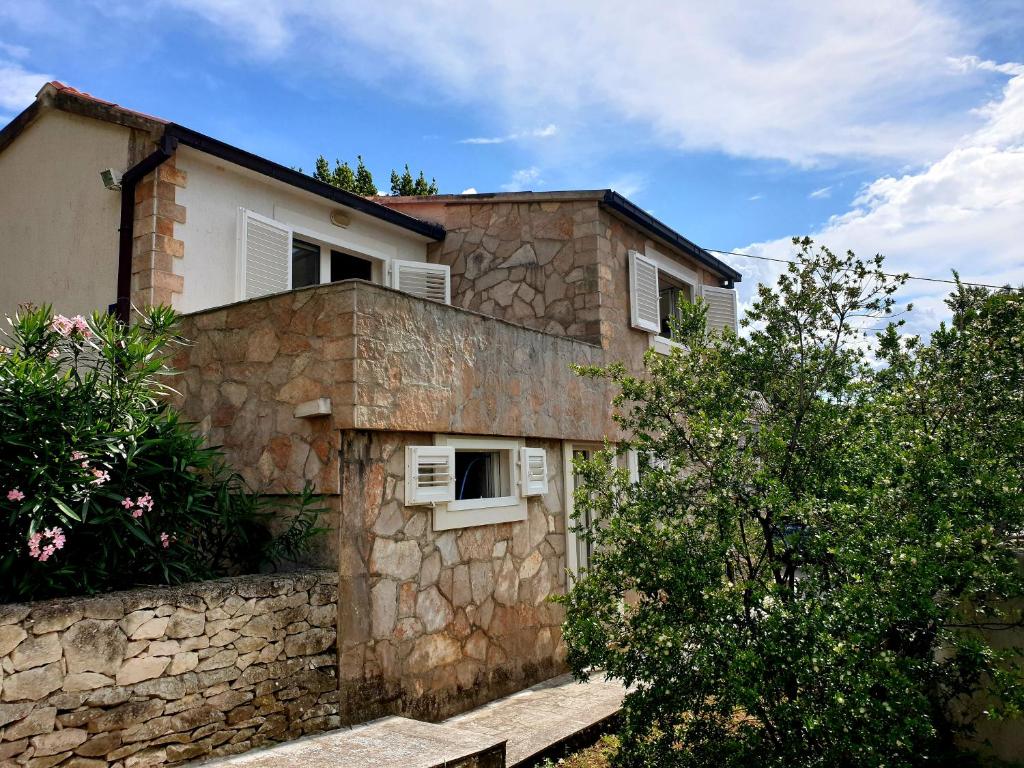 ein Steinhaus mit einer Steinmauer in der Unterkunft Beach House Splitska in Splitska