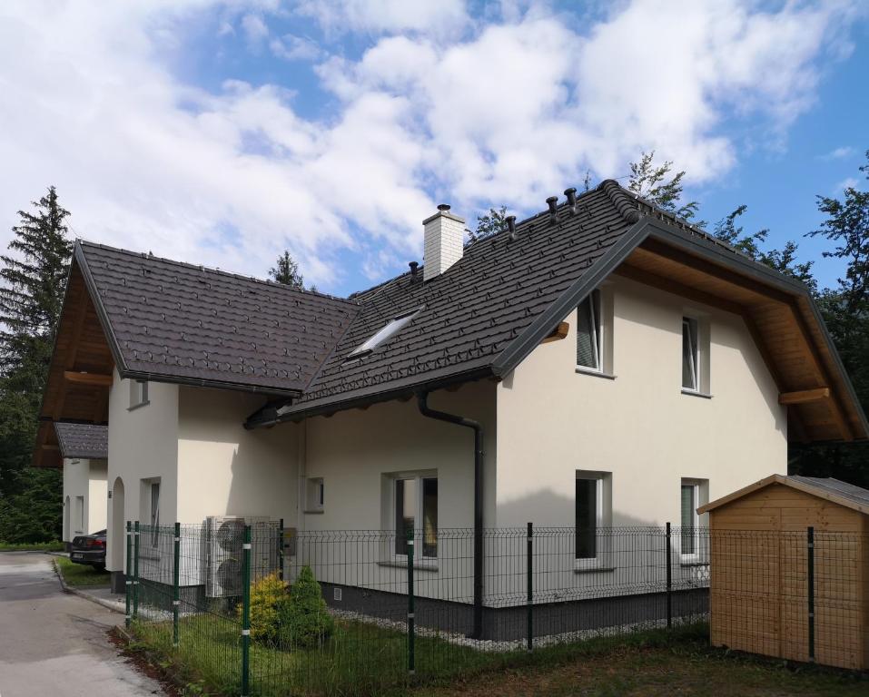 ein weißes Haus mit schwarzem Dach in der Unterkunft Villa Melody in Bohinj