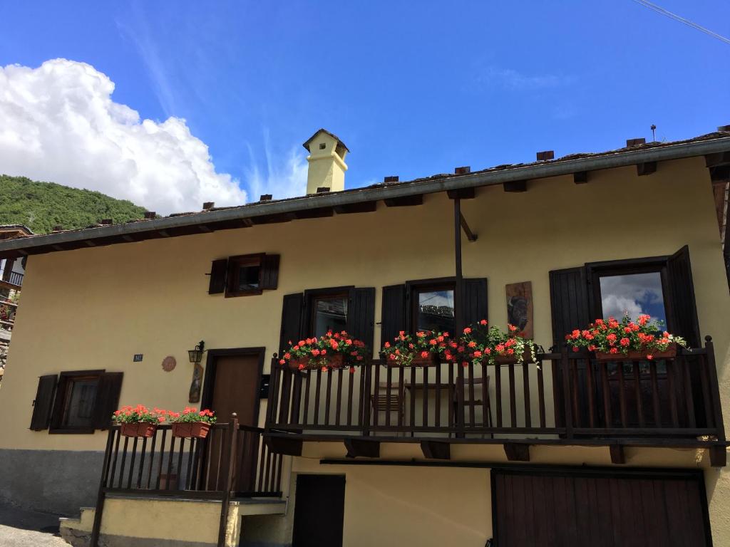 budynek z skrzyniami kwiatowymi na balkonie w obiekcie Aosta Mountain House- Casa La Chapelle w Aoście