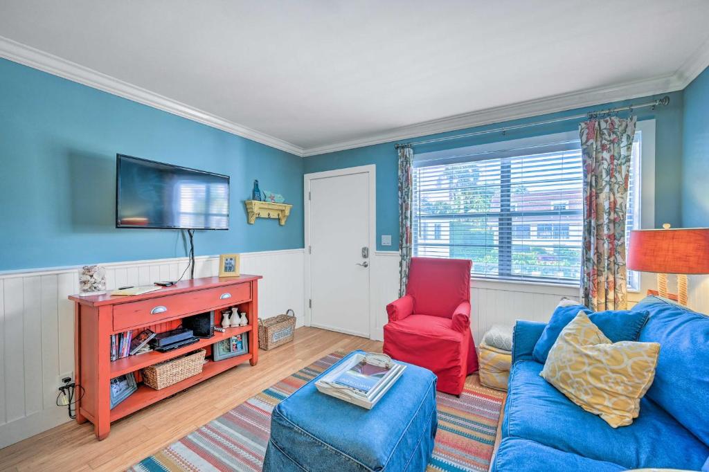 a blue living room with a blue couch and a red chair at Condo with Pool Access Walk to Shopping and Beach! in Naples