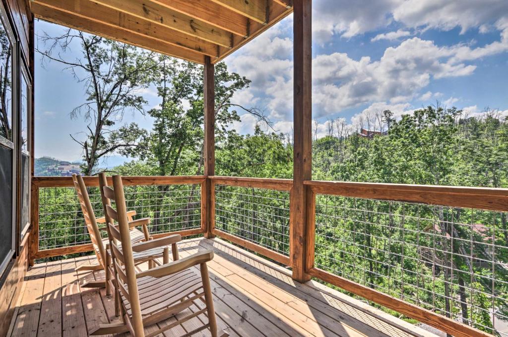 una habitación con 2 sillas en una terraza con árboles en Modern Gatlinburg Cabin with Hot Tub, Game Room, en Gatlinburg