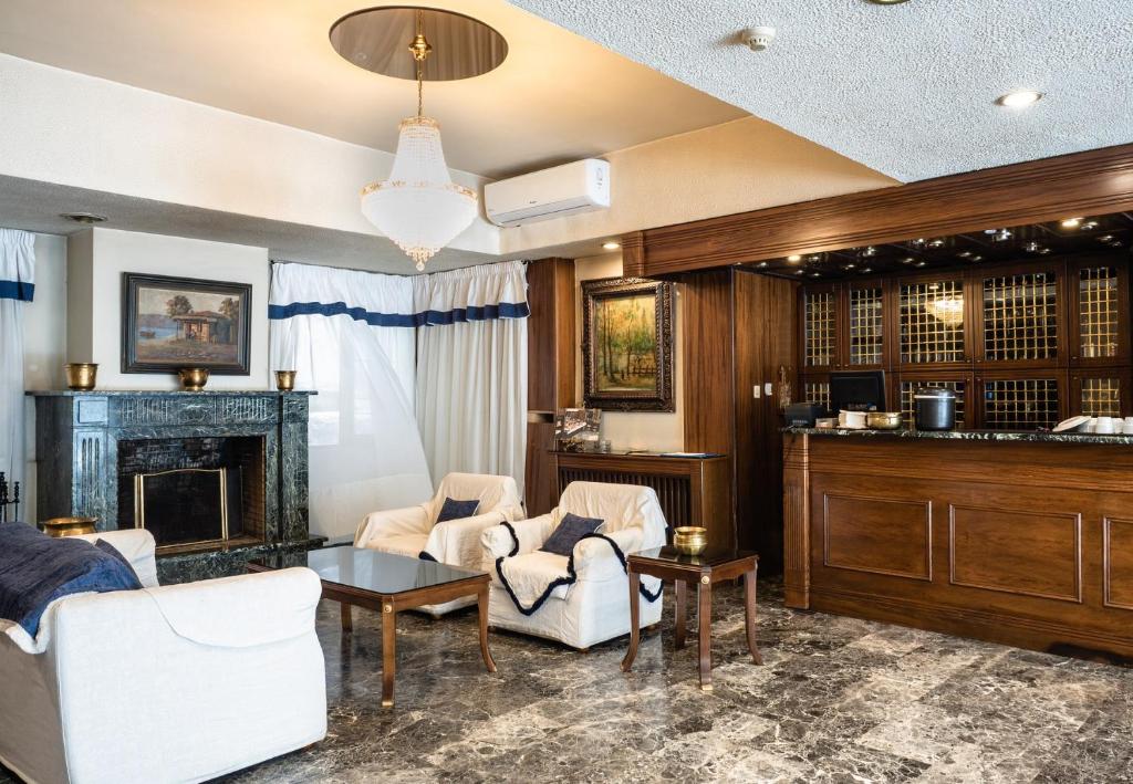 a living room with two chairs and a fireplace at Hotel Elena in Larisa