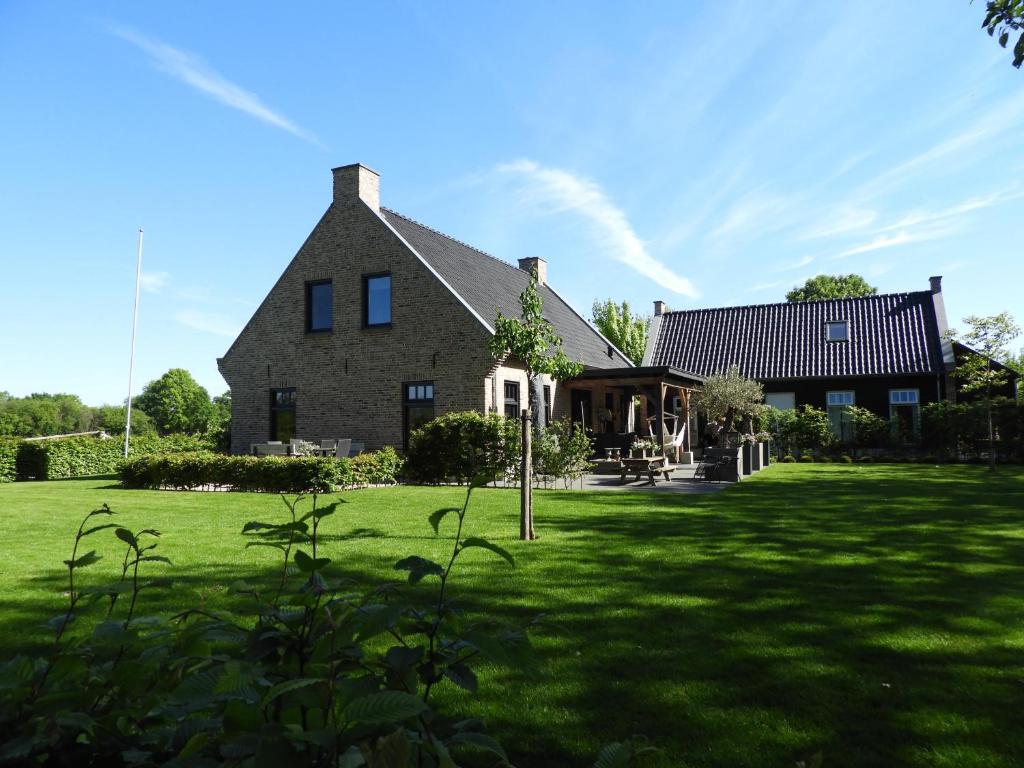 ein großes Haus mit einem großen Rasenplatz in der Unterkunft Bed & Breakfast Bennekom in Bennekom