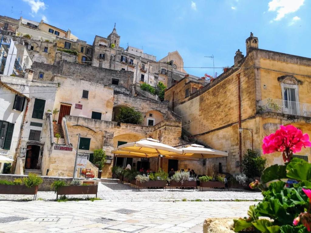 an old building with umbrellas in front of it at La Casa Nei Sassi in Matera