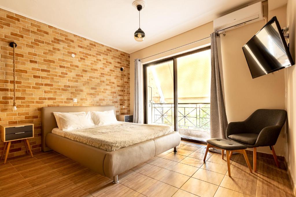 - une chambre avec un lit, une chaise et un mur en briques dans l'établissement Bonnie & Clyde, à Kalamata