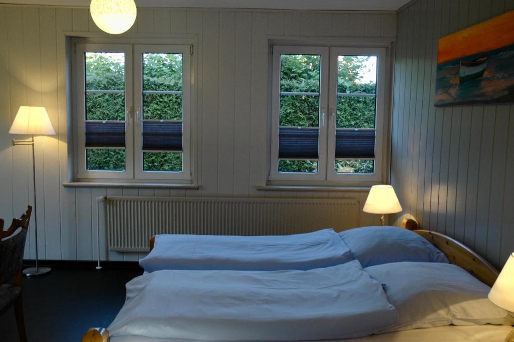 a bedroom with a bed with three windows at Hotel Kappelner Hof in Kappeln