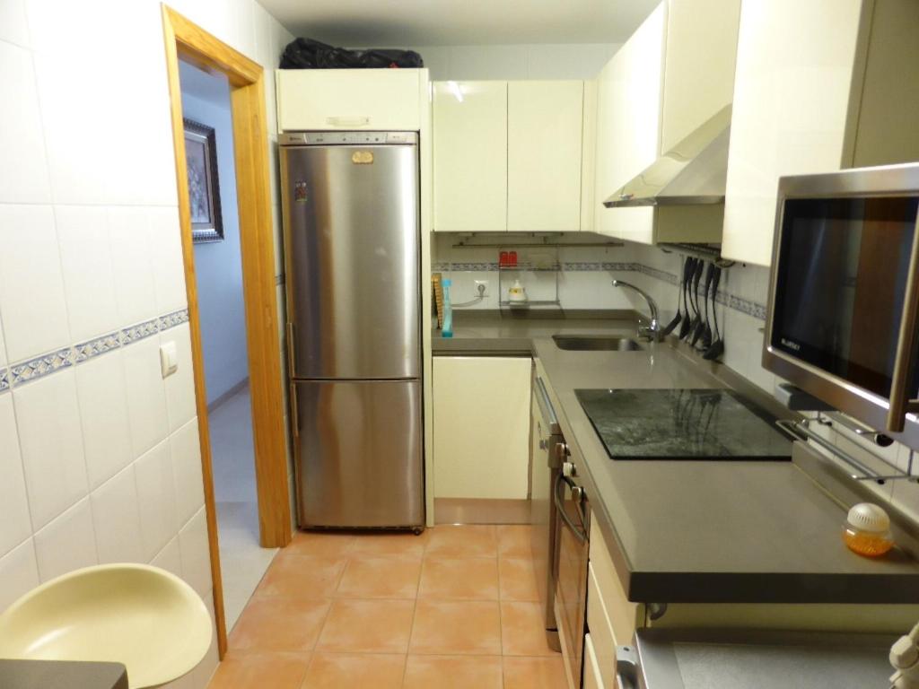 A kitchen or kitchenette at Apartamento con terraza, garaje y piscina a 350m playa