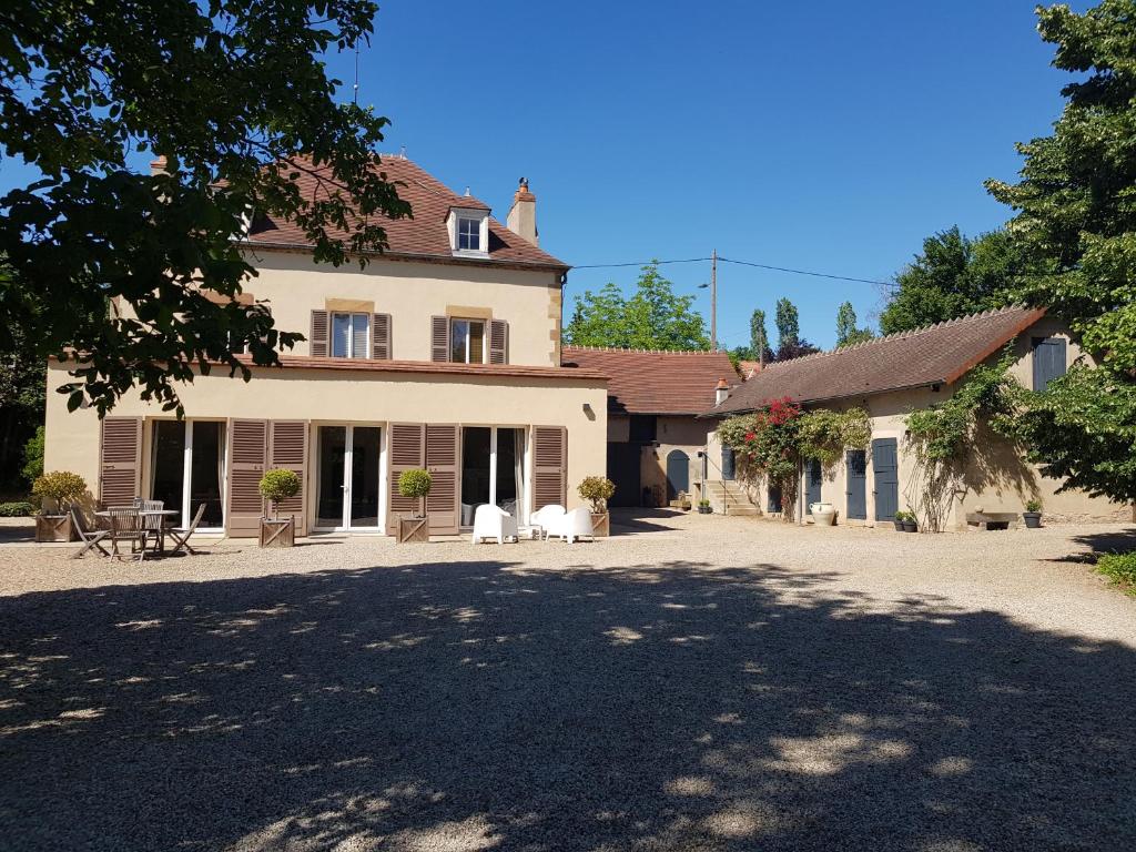 - un grand bâtiment blanc avec une allée devant dans l'établissement Le Verger Moulins Yzeure, à Yzeure