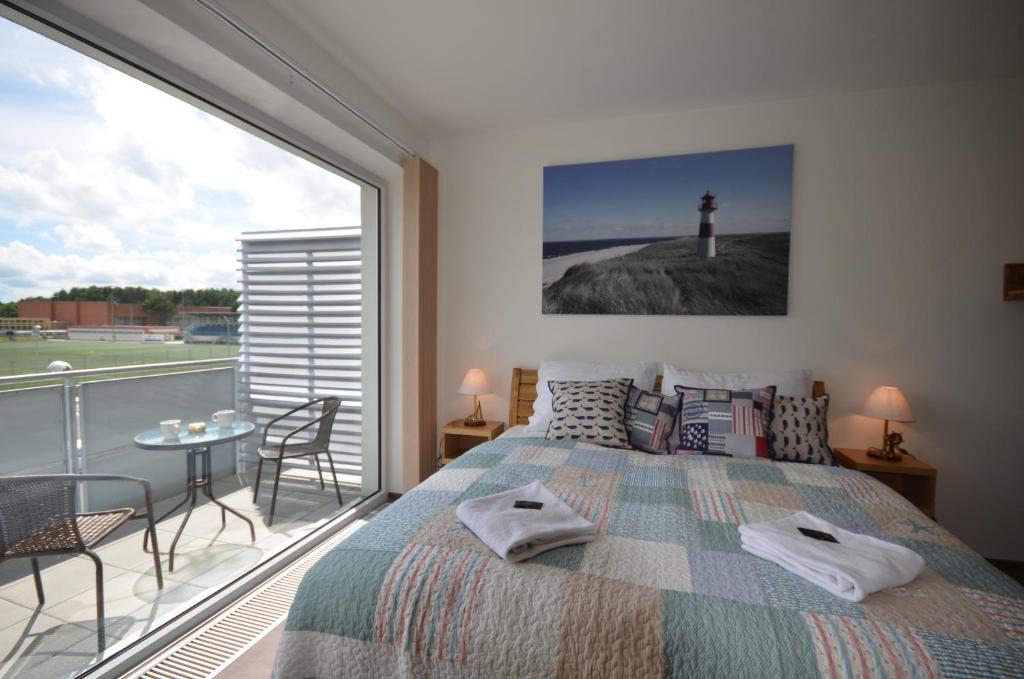 a bedroom with a bed and a balcony with a lighthouse at Apartmány Viva Třeboň in Třeboň