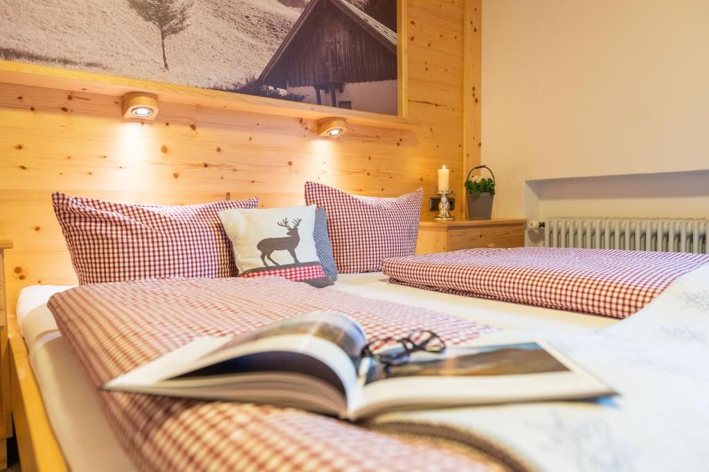 two beds with a book on top of them at Pension Hartmann in Fischen