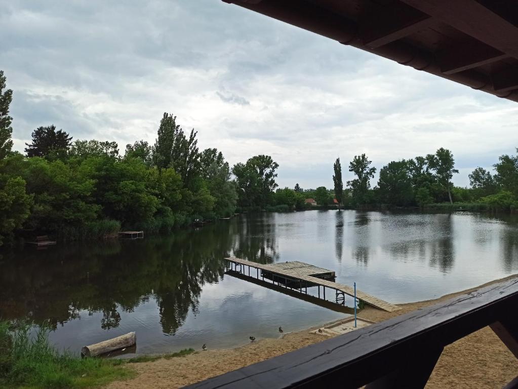 a river with a dock in the middle of it at Éden Lounge Restaurant & Pension in Veresegyház