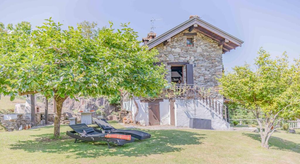 uma casa de pedra com duas cadeiras em frente em Solivo Farm em Cannobio