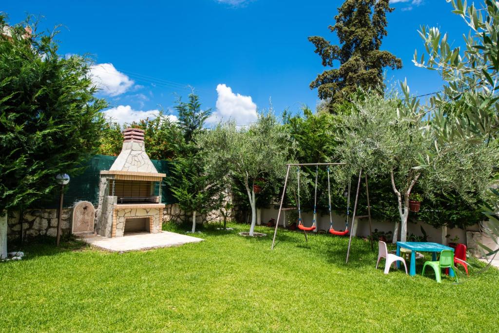 a backyard with a picnic table and a playground at Villa Nektaria in Nikiana