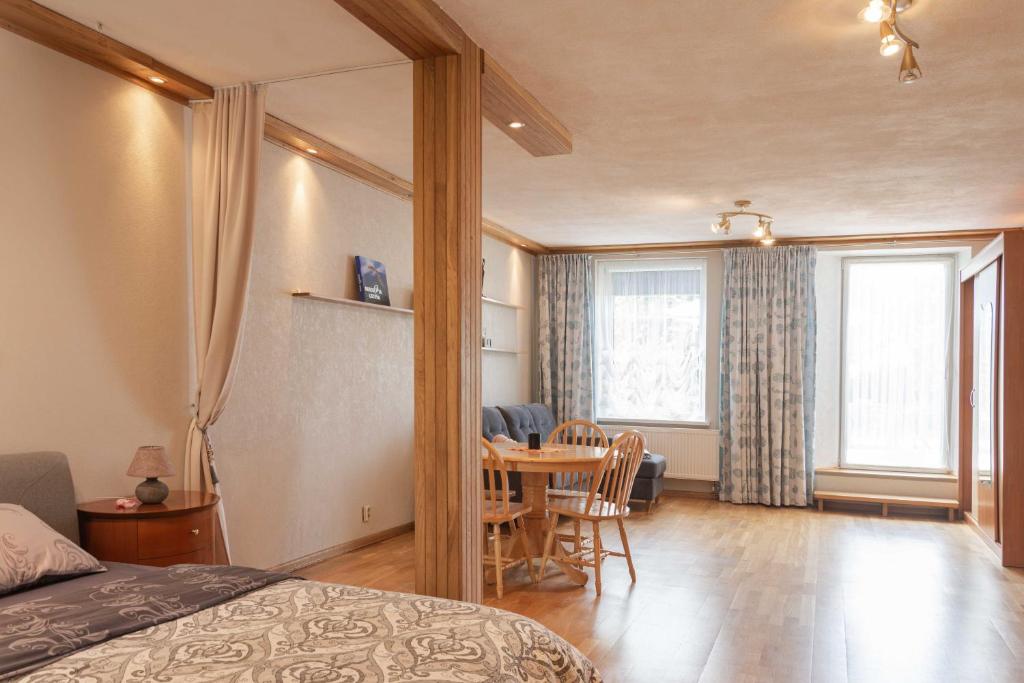 a bedroom with a table and a dining room at Cozy one room apartment with yard in Juodkrantė
