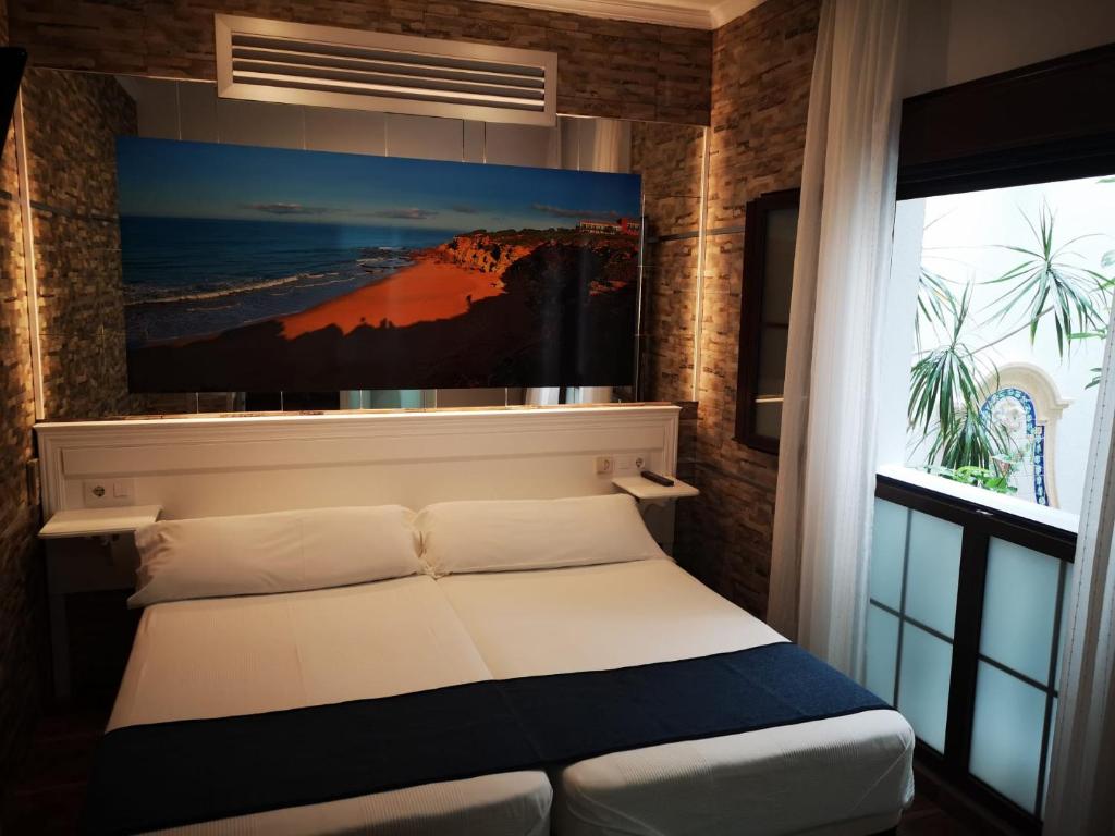 Łóżko lub łóżka w pokoju w obiekcie Hostal Costa De La Luz