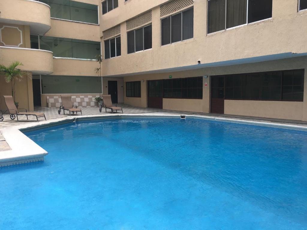 a large swimming pool in front of a building at Hotel Acuario de Veracruz in Veracruz