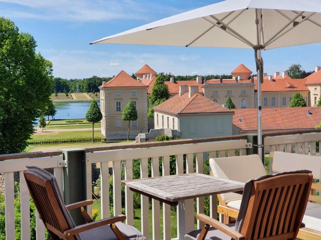 una mesa y sillas en un balcón con vistas en LoggiaHaus am Schloss, 5 Ferienwohnungen, teils mit Schloss- und Seeblick, en Rheinsberg