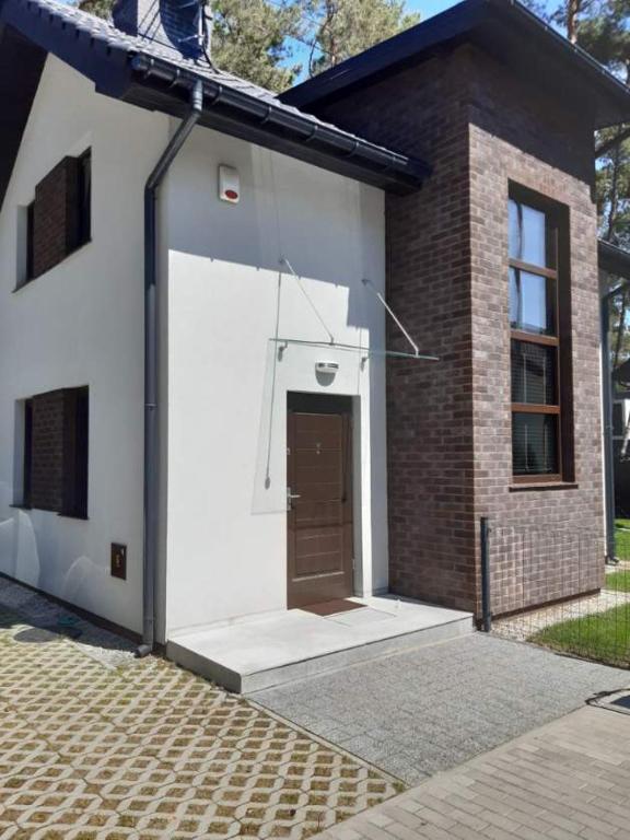 a white garage with a brown door on a building at Dwie Mewy in Pobierowo