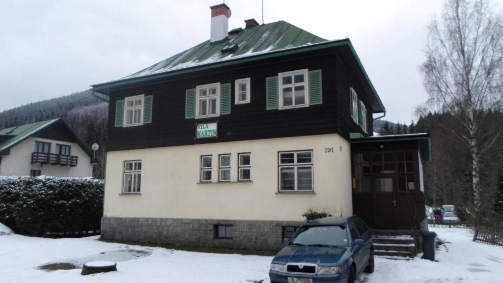 a house with a car parked in front of it at Vila Martin in Harrachov
