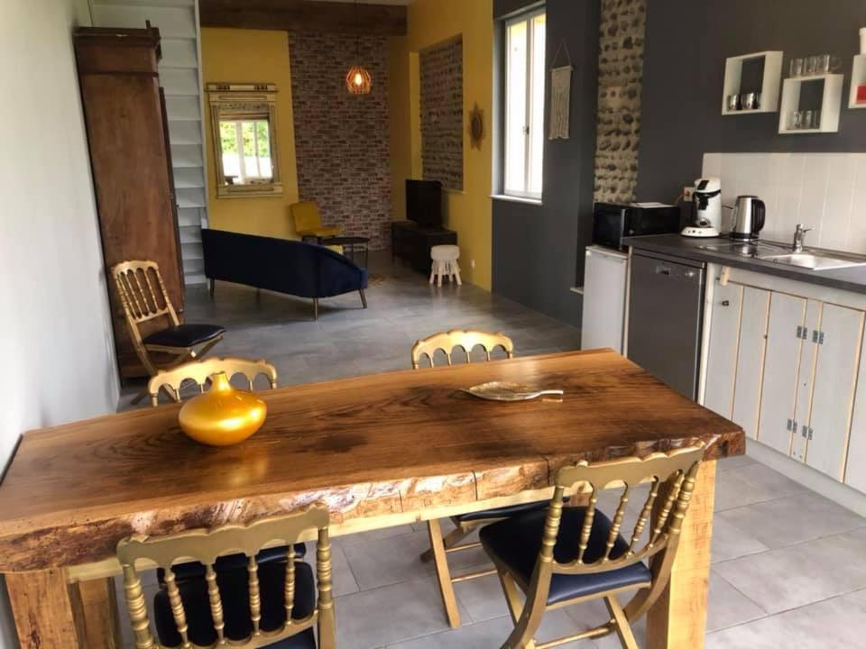 a kitchen and dining room with a wooden table and chairs at Domaine Saint Esselin in Larreule