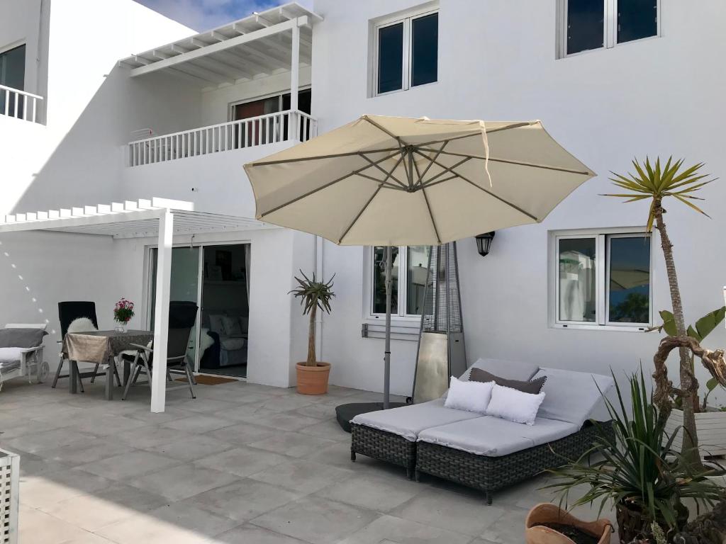 patio con divano e ombrellone di Romantic Casa Blanca a Costa Teguise
