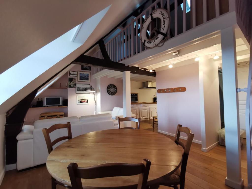 uma sala de jantar e sala de estar com mesa e cadeiras em Phare des Impressionnistes em Honfleur