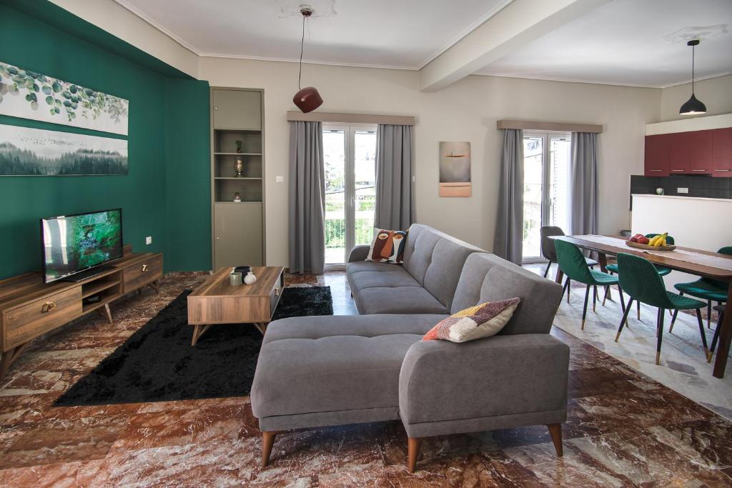 uma sala de estar com um sofá e uma mesa em Emerald 110m2 entire floor apt steps to city’s heart em Kalamata