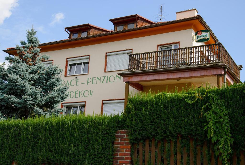 un bâtiment avec une clôture devant lui dans l'établissement Penzion Bezděkov, à Rakovník