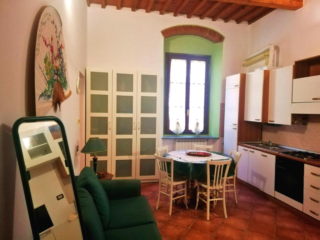 a kitchen with a table and chairs in a room at La casa di Giosuè in Livorno