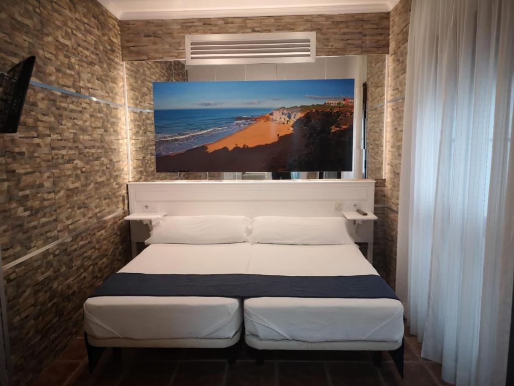 Łóżko lub łóżka w pokoju w obiekcie Hostal Costa De La Luz