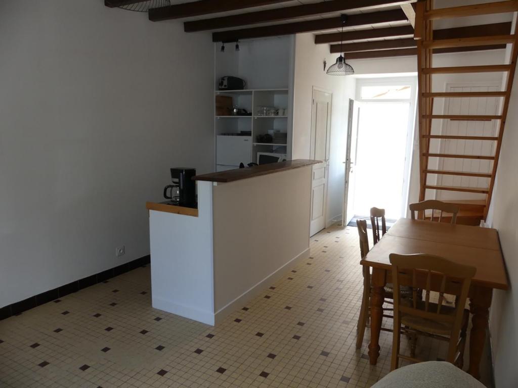 - une cuisine et une salle à manger avec une table et des chaises dans l'établissement Petit gite du Puy Lambert, à La Flocellière