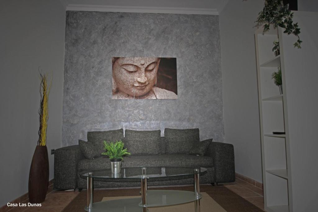 a living room with a couch and a bust at Casa las Dunas in Valle Gran Rey