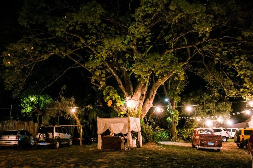 a tent under a tree in a yard at night at Reduto das Artes Hostel pousada in Casa Branca