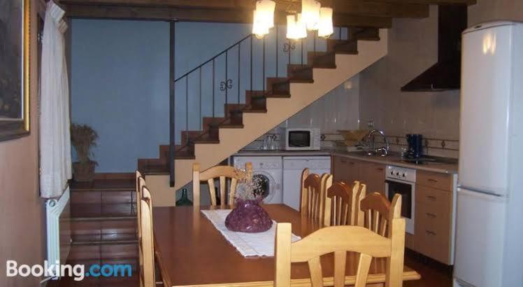 a kitchen with a table and chairs and a staircase at Casa Rural Lo Ferrero in Belsué