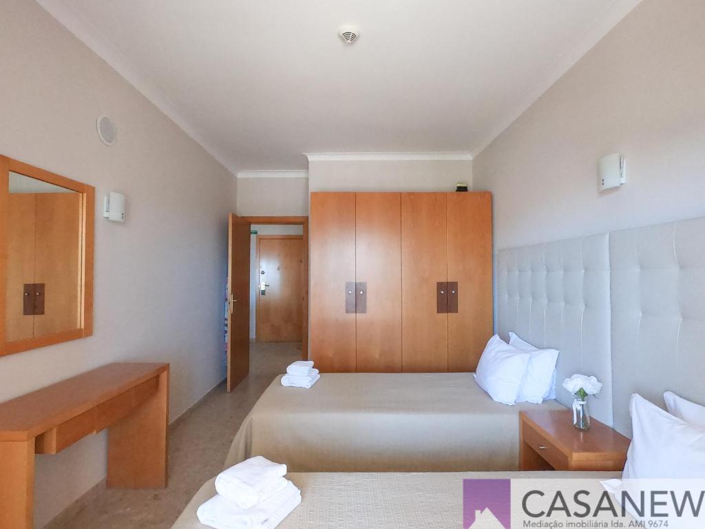 a bedroom with two beds and a wooden cabinet at Praia Mar in Portimão