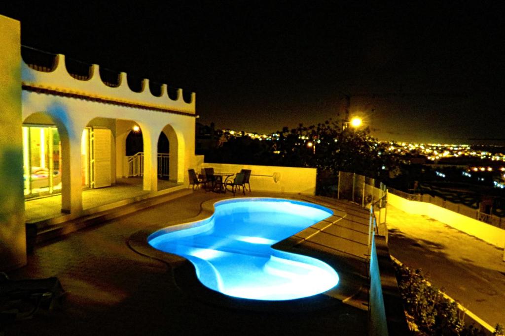 uma piscina com luzes azuis num edifício à noite em Villa Esmeralda em Albufeira