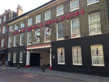 een groot bakstenen gebouw met een bord erop bij The Royal Victoria & Bull Hotel in Rochester