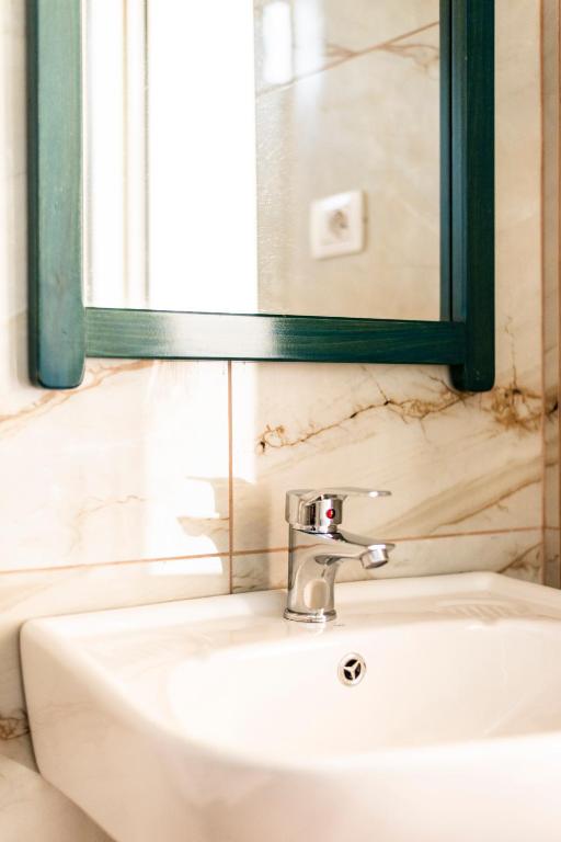 a bathroom sink with a mirror and a sink at Janakis Garden Livadi Beach in (( Spile ))