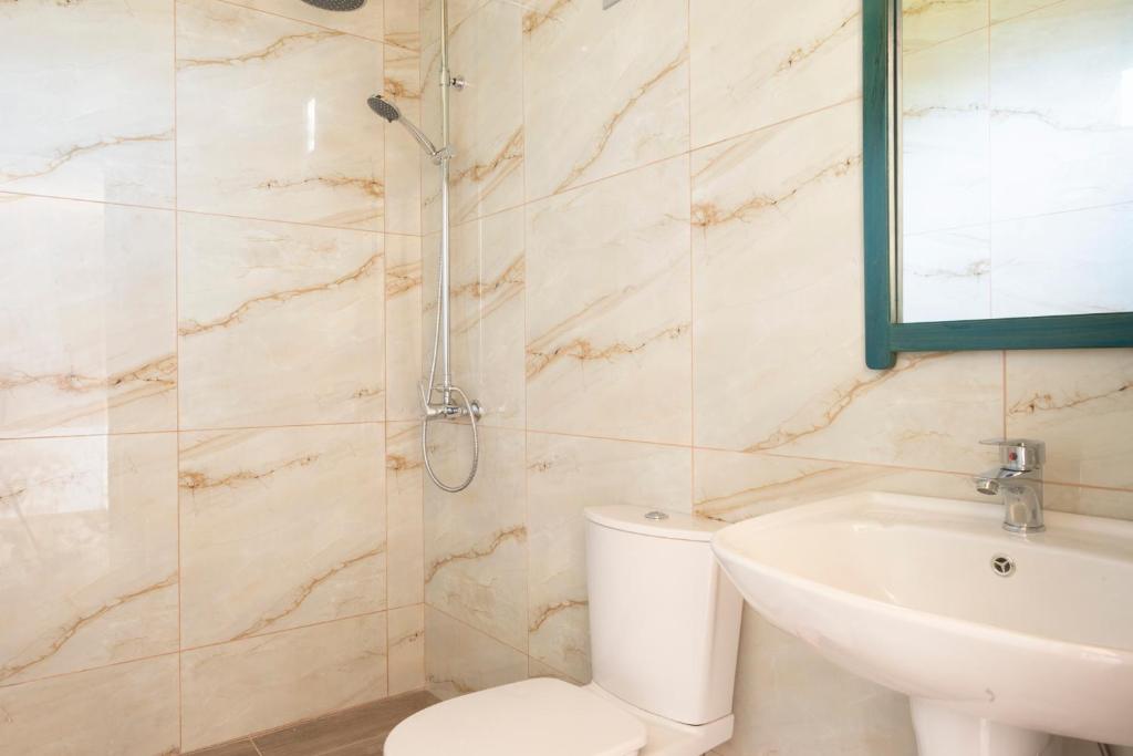a bathroom with a toilet and a sink and a shower at Janakis Garden Livadi Beach in (( Spile ))