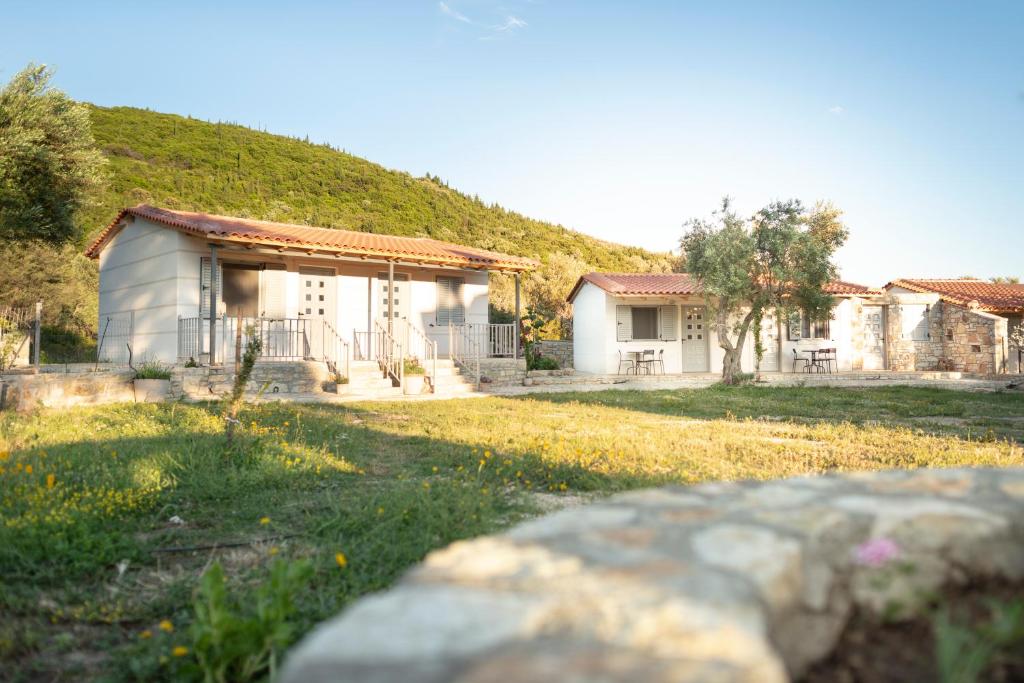 a house with a hill in the background at Janakis Garden Livadi Beach in (( Spile ))