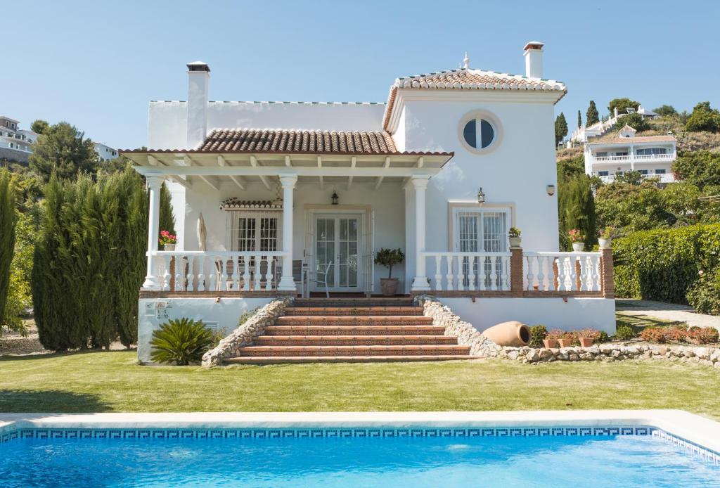 Biały dom z basenem przed nim w obiekcie Villa las Tinajas Luxury w mieście Nerja