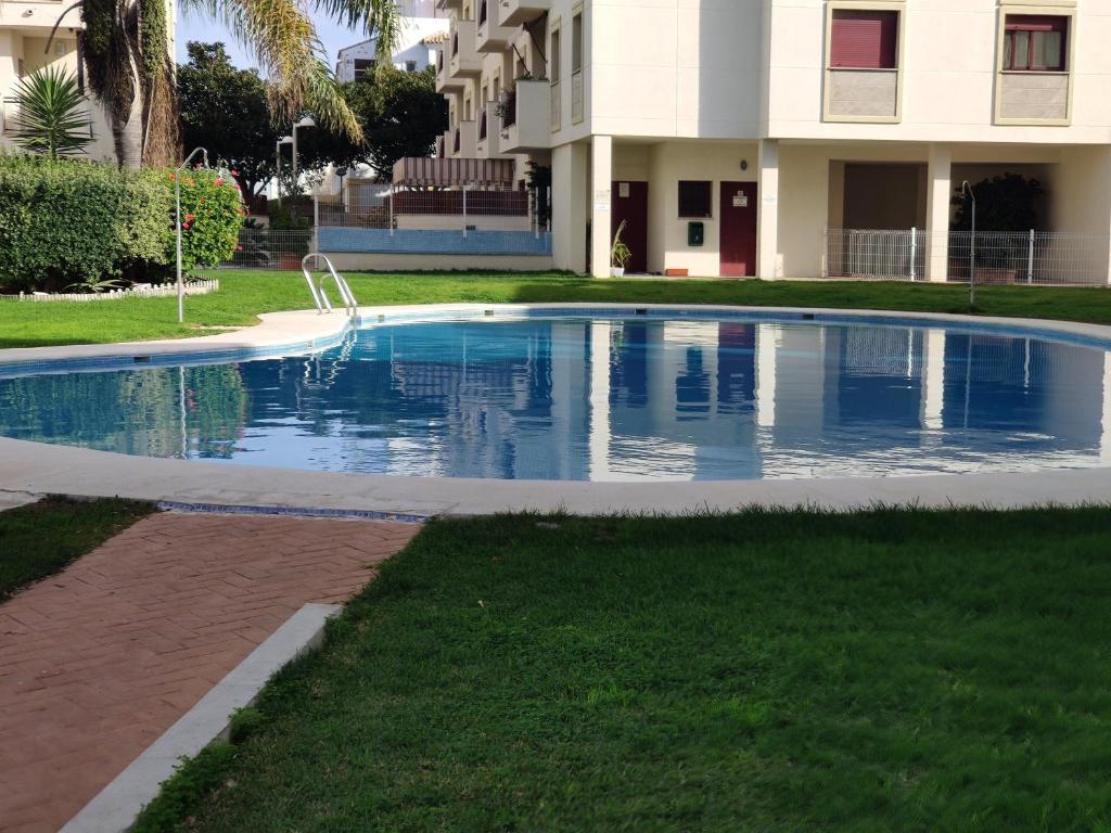 a swimming pool in front of a building at VALDECARRETAS Apartamento Rota cerca de playa in Rota