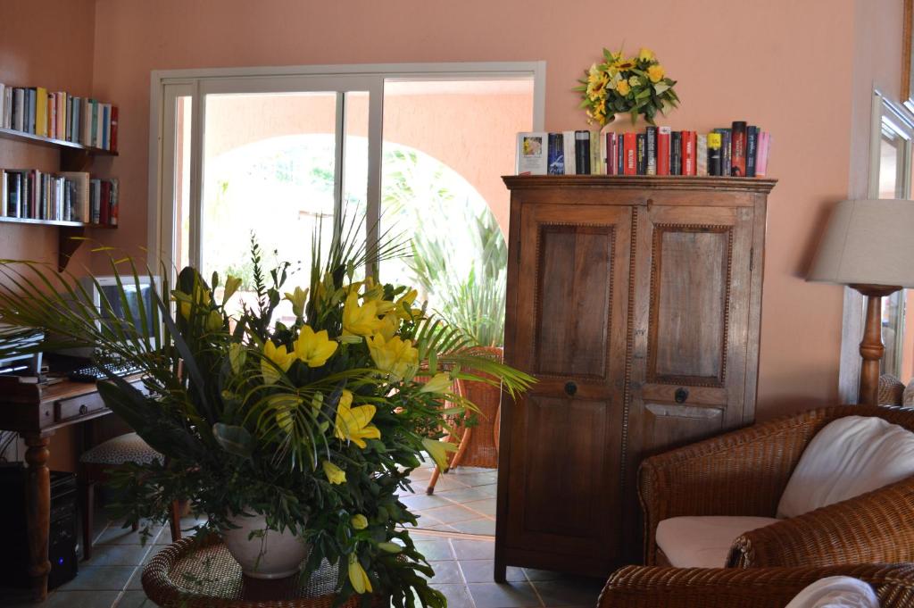 a living room with yellow flowers and a cabinet at Residence Fenicia in Villasimius