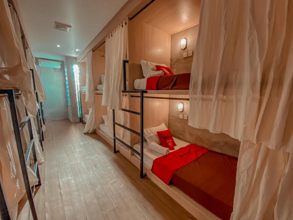 a room with three bunk beds in a room at RedDoorz Hostel near Lippo Mall Kuta in Kuta