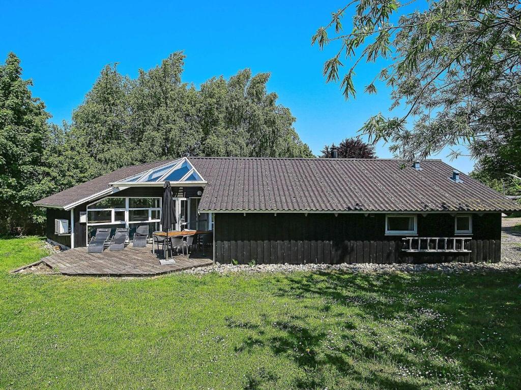 a cabin with a deck and a table and chairs at Four-Bedroom Holiday home in Gilleleje 1 in Gilleleje