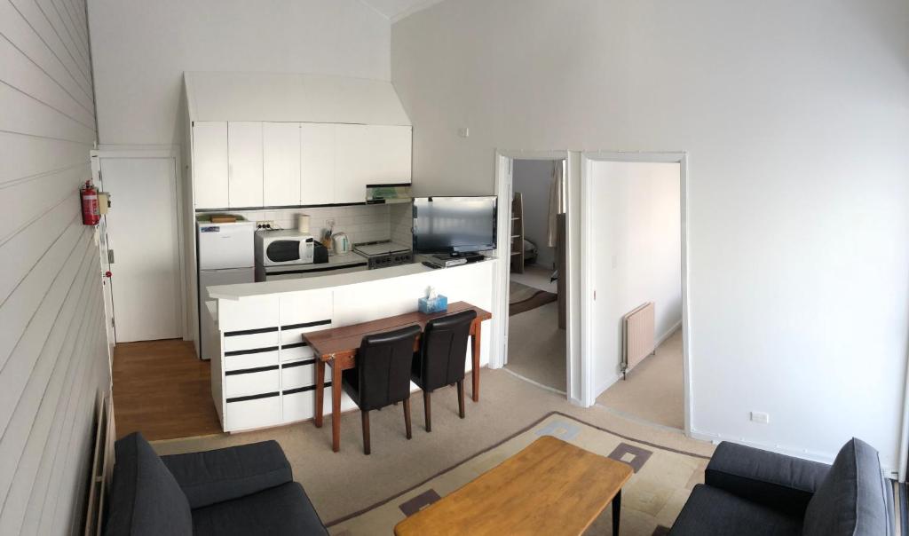 a living room with a table and a kitchen at Shamrock Apartment 4 in Mount Hotham