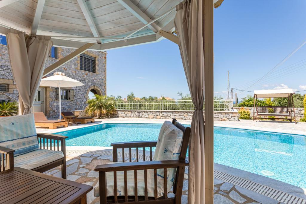 a villa with a swimming pool and a patio at Villa Angeliki in Lévktron