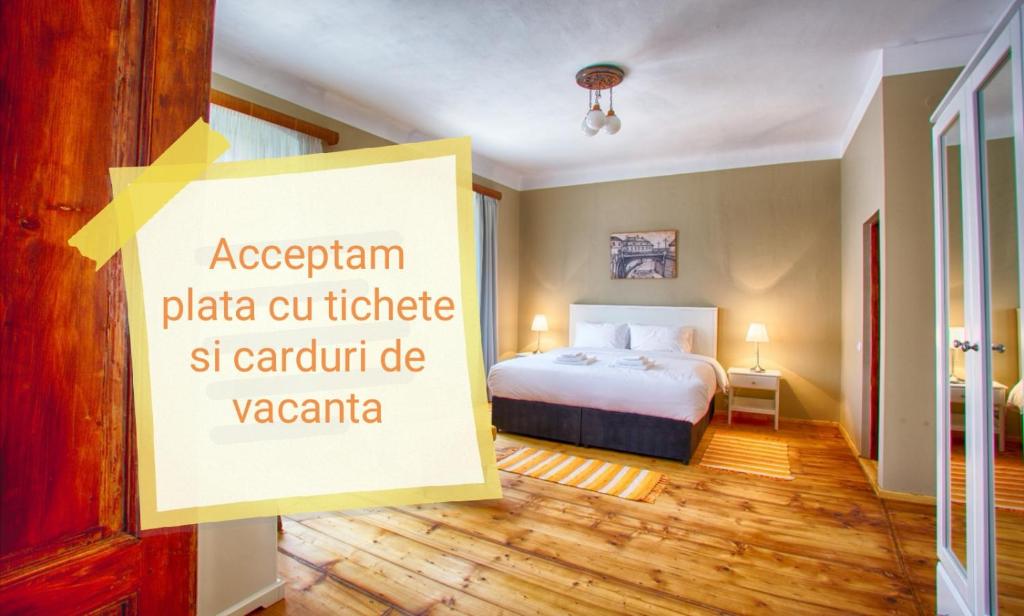 a hotel room with a bed and a sign that reads acergán plaza cu at Goldsmith in Sibiu