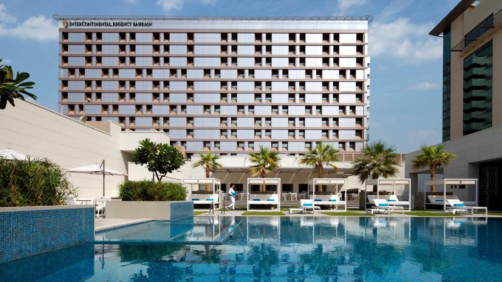 マナーマにあるInterContinental Bahrain, an IHG Hotelの建物の前にスイミングプールがあるホテル